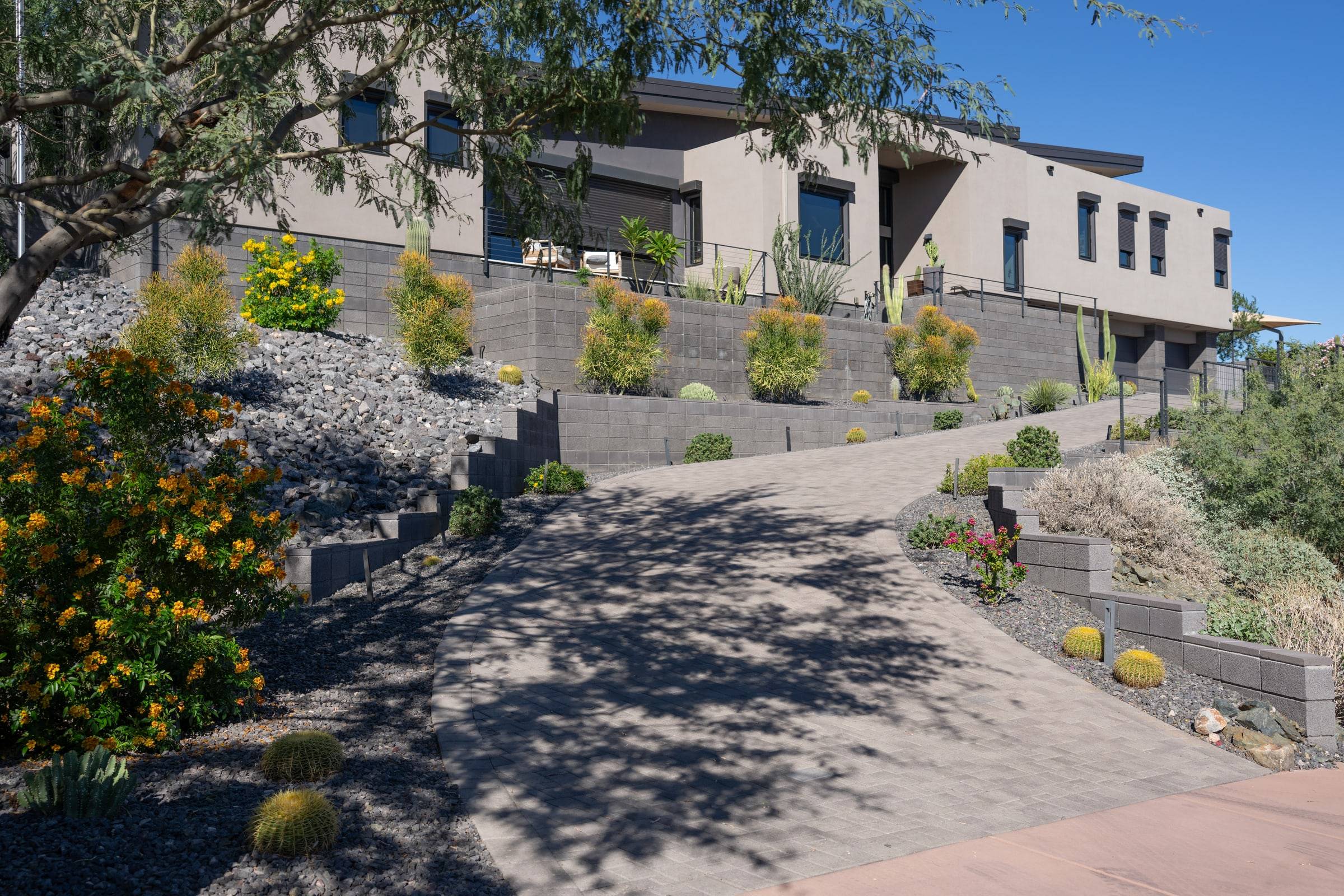 Modern home with grey block retaining walls and desert landscaping