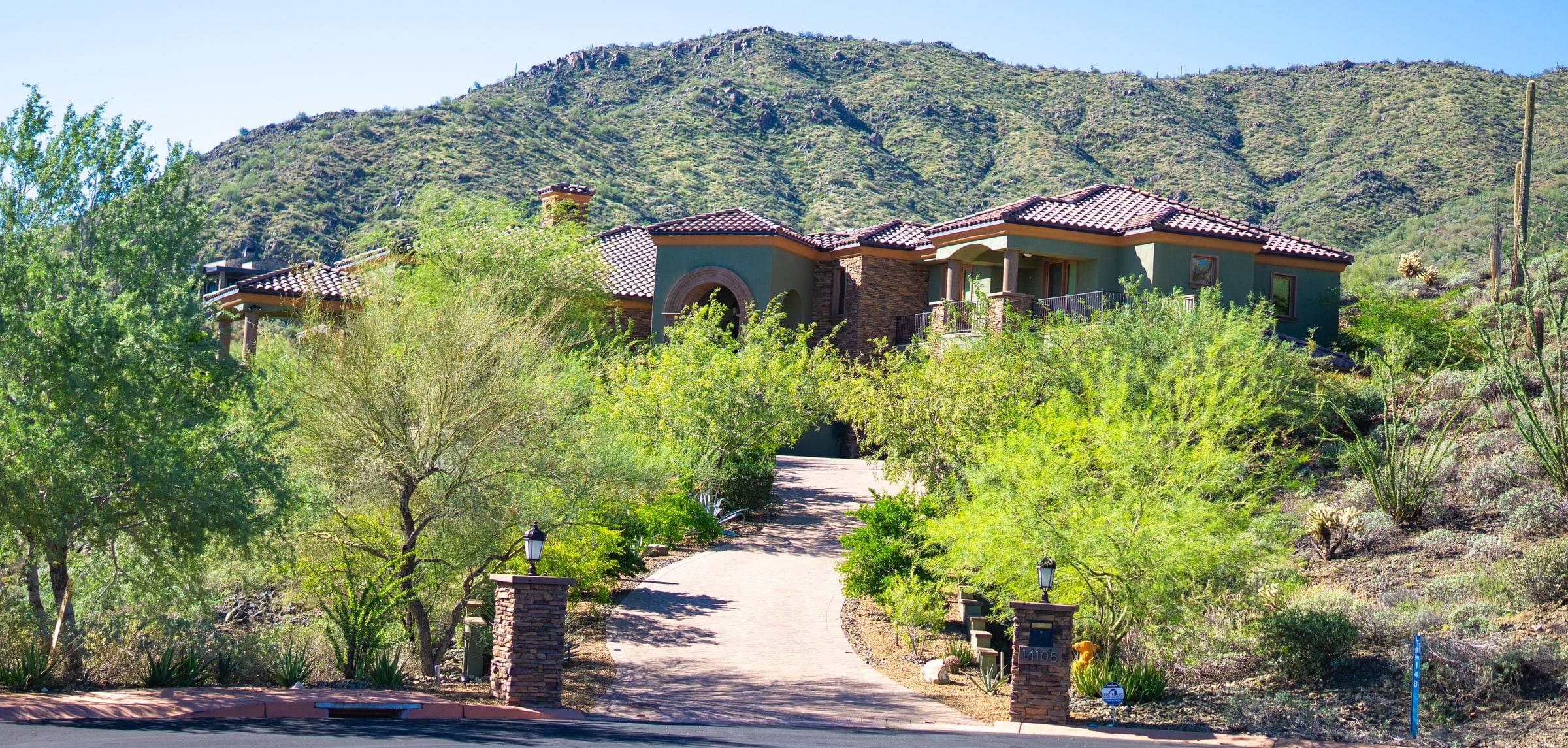 Tuscan-style estate with gated entry and mountain backdrop
